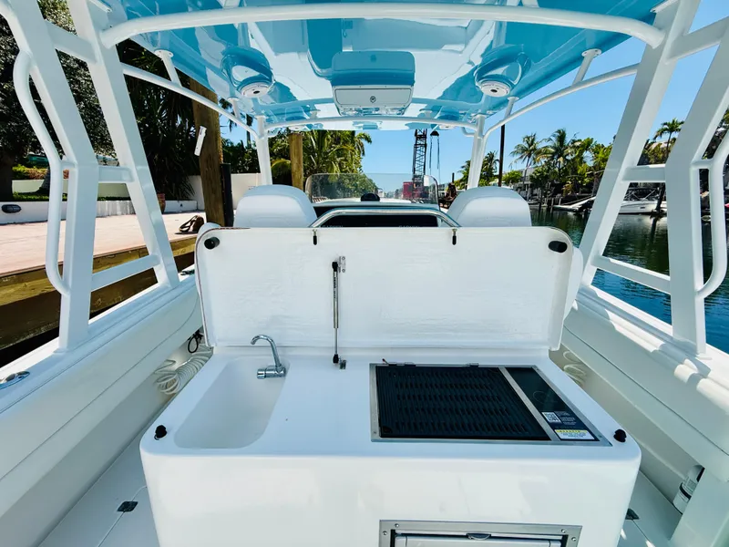 Slide: The Image of 2003 Intrepid 377 boat interior with sink and grill, docked by a canal. - 50