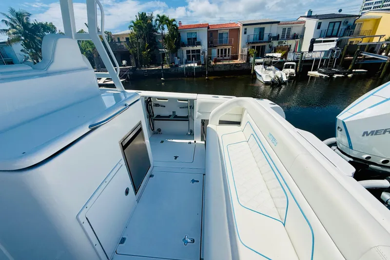 Slide: The Image of 2003 Intrepid 377 boat interior with seating, docked near waterfront homes. - 59