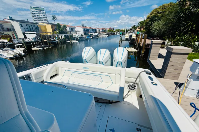 Slide: The Image of 2003 Intrepid 377 boat docked in a scenic canal with triple Mercury engines. - 60