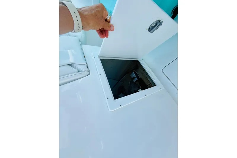 Slide: The Image of Person opening hatch on 2003 Intrepid 377 boat deck, revealing storage compartment. - 62