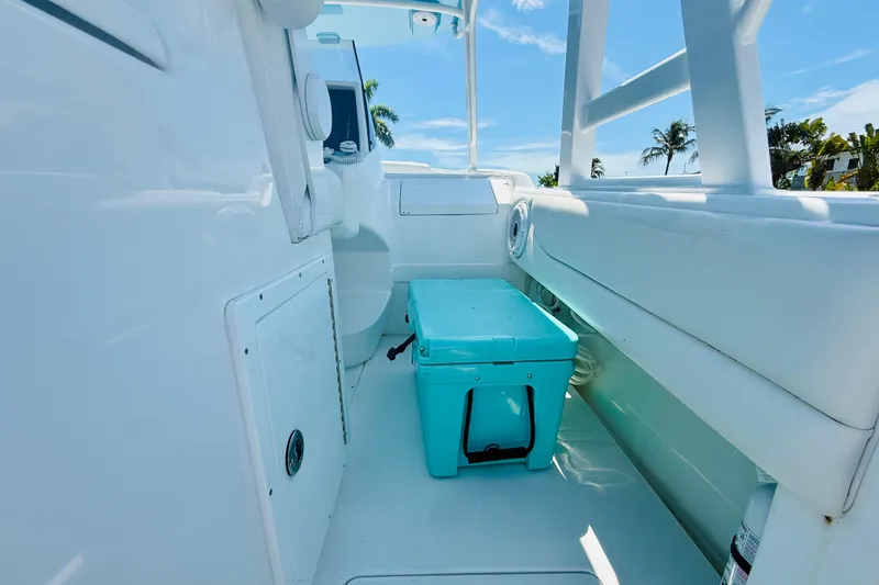 Slide: The Image of 2003 Intrepid 377 boat interior with turquoise cooler, white seating, and clear blue sky. - 63