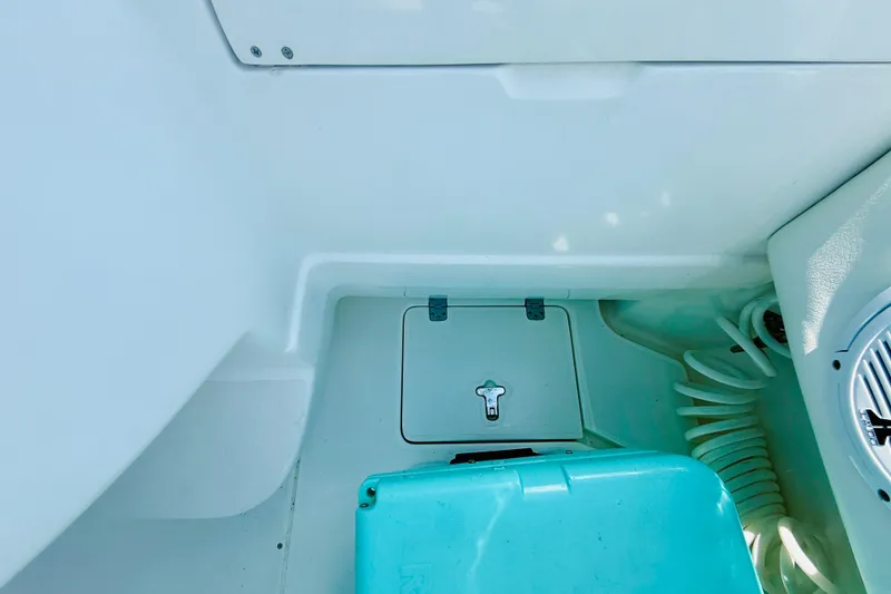Slide: The Image of Interior view of a 2003 Intrepid 377 boat, featuring storage compartment and turquoise container. - 64