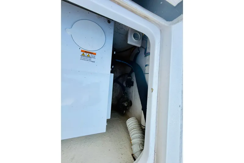 Slide: The Image of Interior view of a 2003 Intrepid 377 boat compartment with visible machinery and warning labels. - 68