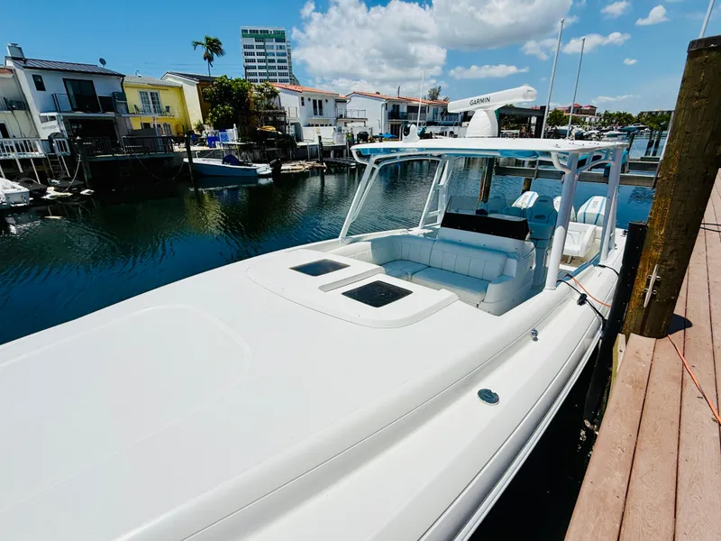 Slide: The Image of 2003 Intrepid 377 boat docked in a scenic waterfront setting under a clear blue sky. - 7