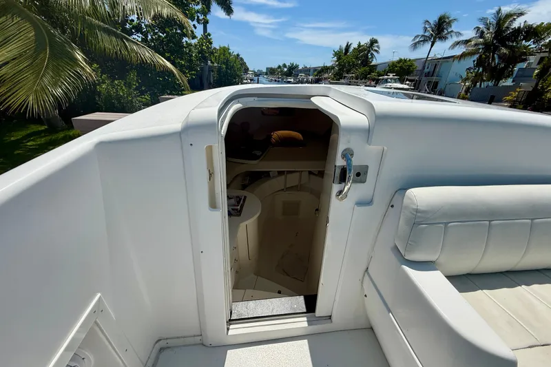 Slide: The Image of 2003 Intrepid 377 boat interior view with open cabin door, tropical setting. - 79