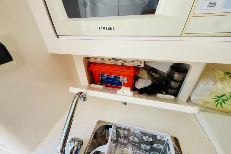 Slide: The Image of 2003 Intrepid 377 boat interior with storage compartment and Samsung microwave. - 81