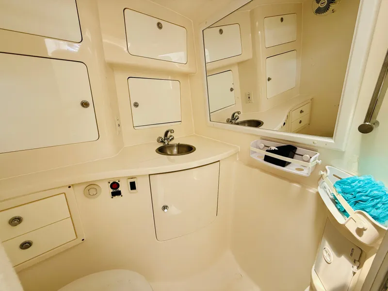 Slide: The Image of 2003 Intrepid 377 boat bathroom with sink, storage cabinets, and mirror. - 83
