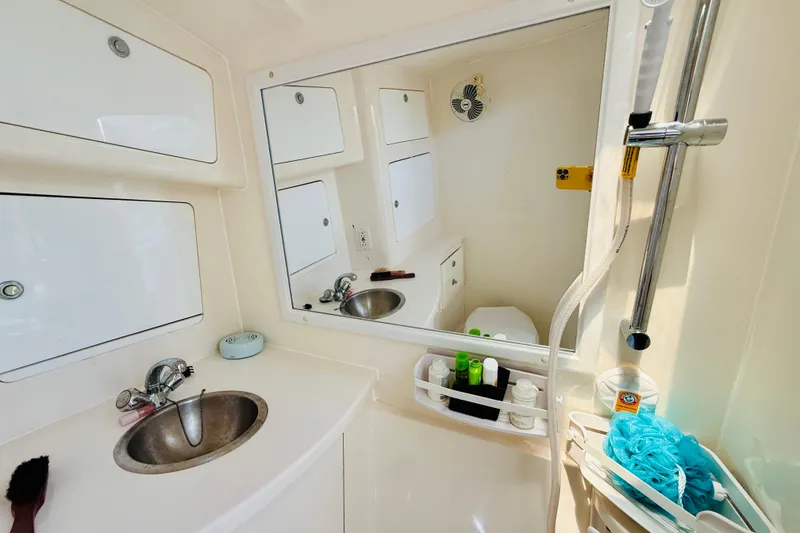 Slide: The Image of Compact bathroom in a 2003 Intrepid 377 boat, featuring sink, mirror, and shower amenities. - 89