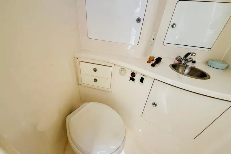 Slide: The Image of 2003 Intrepid 377 boat bathroom with sink, toilet, and storage cabinets. - 91