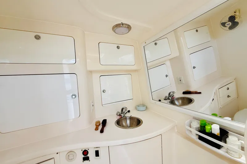 Slide: The Image of Luxurious bathroom interior of 2003 Intrepid 377 boat with sink, mirror, and storage cabinets. - 92