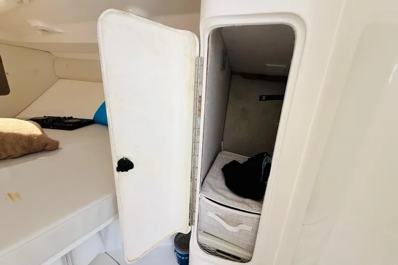 Slide: The Image of Interior cabin storage of 2003 Intrepid 377 boat with open closet and bedding. - 95