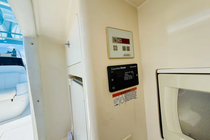 Slide: The Image of Interior of a 2003 Intrepid 377 boat featuring a Cummins Onan generator control panel. - 96