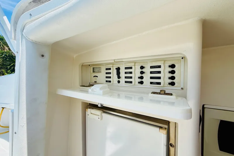 Slide: The Image of Control panel on a 2003 Intrepid 377 boat, featuring switches and a gauge. - 97
