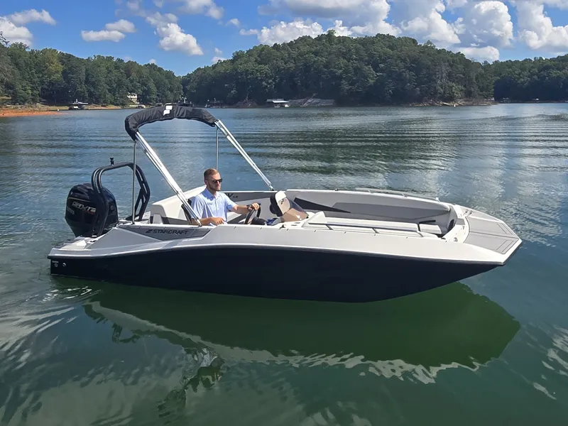 Slide: The Image of A modern 2027 Starcraft 181SVOB on a calm lake with wooded shores. - 29