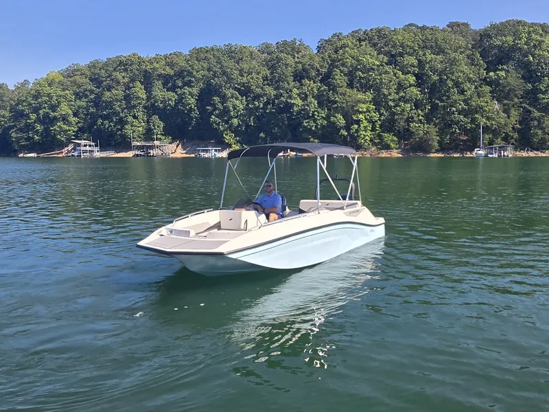 Slide: The Image of A 2027 Starcraft 181SVOB boat cruising on a calm lake with a wooded shoreline. - 1