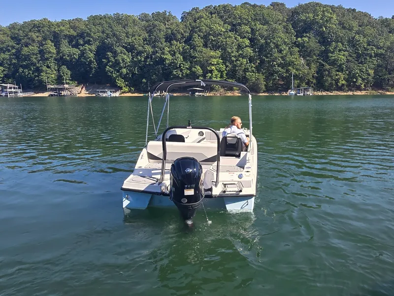 Slide: The Image of A 2027 Starcraft 181SVOB boat on a calm lake with lush forest in the background. - 23