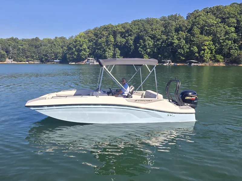 Slide: The Image of A 2027 Starcraft 181SVOB on a calm lake with a wooded shoreline. - 0