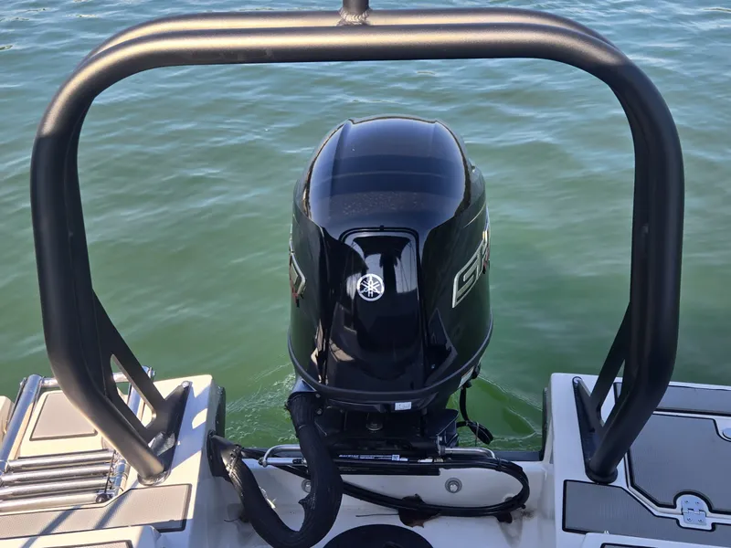 Slide: The Image of An outboard motor on a boat in calm water, surrounded by a sturdy railing. - 6