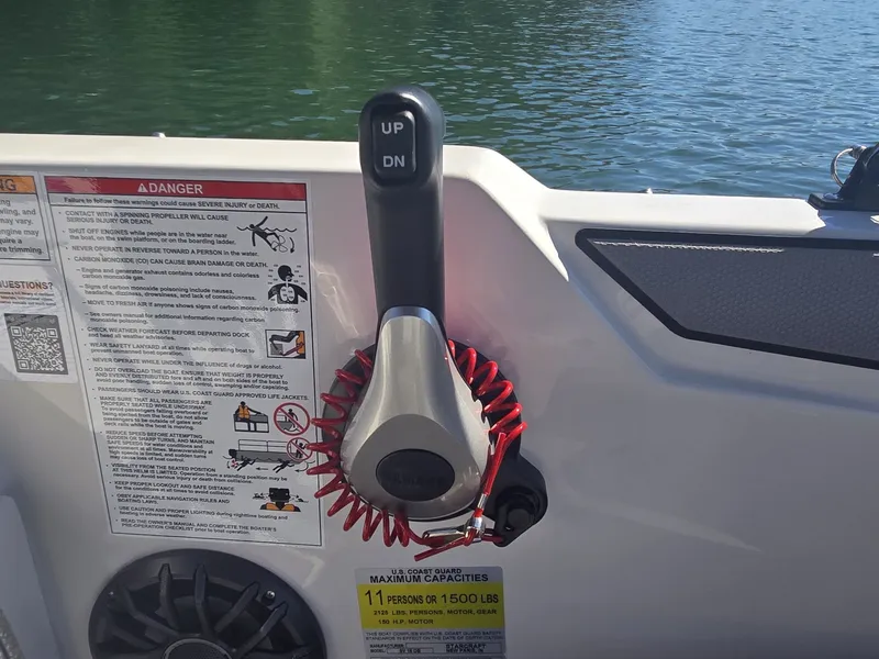 Slide: The Image of Close-up of a boat throttle lever with safety stickers and a red safety lanyard. - 15