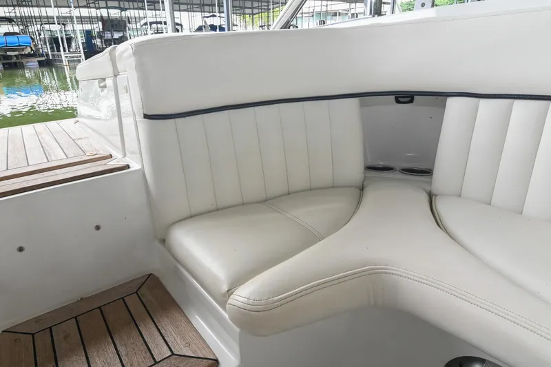 Slide: The Image of 2005 Cobalt 262 boat interior with white cushioned seating and wooden flooring. - 17