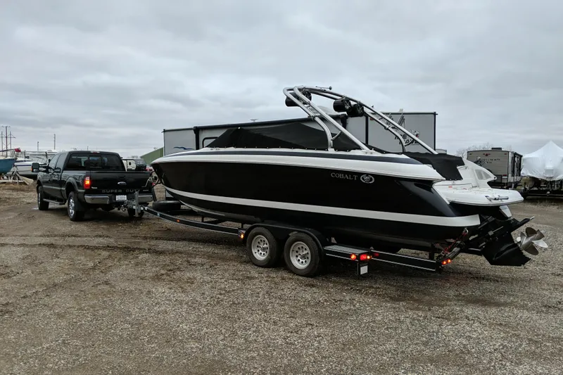 Slide: The Image of 2005 Cobalt 262 boat on trailer, towed by a truck in a parking area. - 51