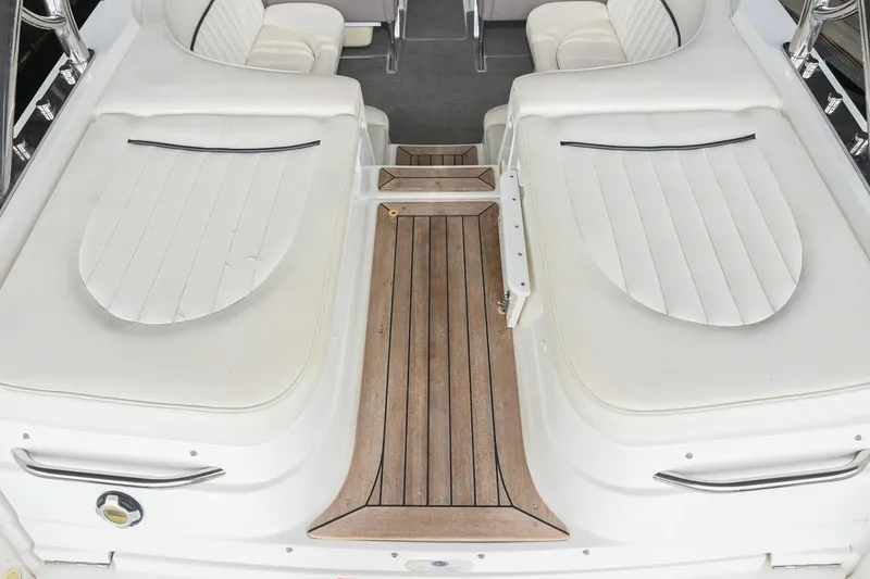 Slide: The Image of 2005 Cobalt 262 boat interior with white seating and wooden deck. - 8