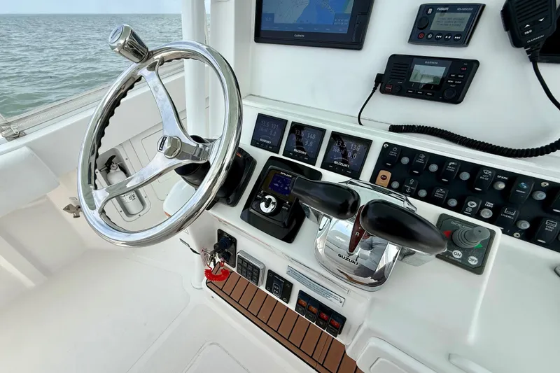 Slide: The Image of 2017 Southport 33 FE boat helm with navigation screens and steering wheel. - 10