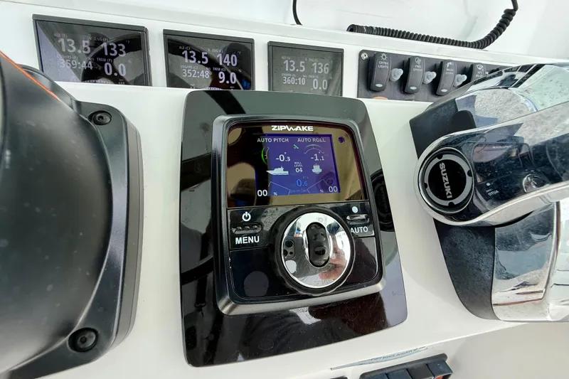 Slide: The Image of Control panel of a 2017 Southport 33 FE boat with Suzuki throttle and switches. - 12