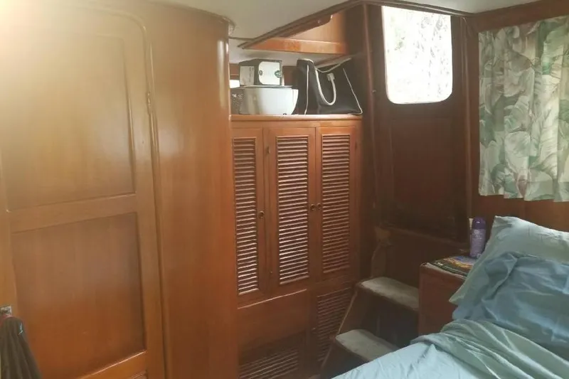 Slide: The Image of Interior of 1991 Offshore Yachts 48 Yachtfisher with wooden cabinets and cozy bedding. - 12