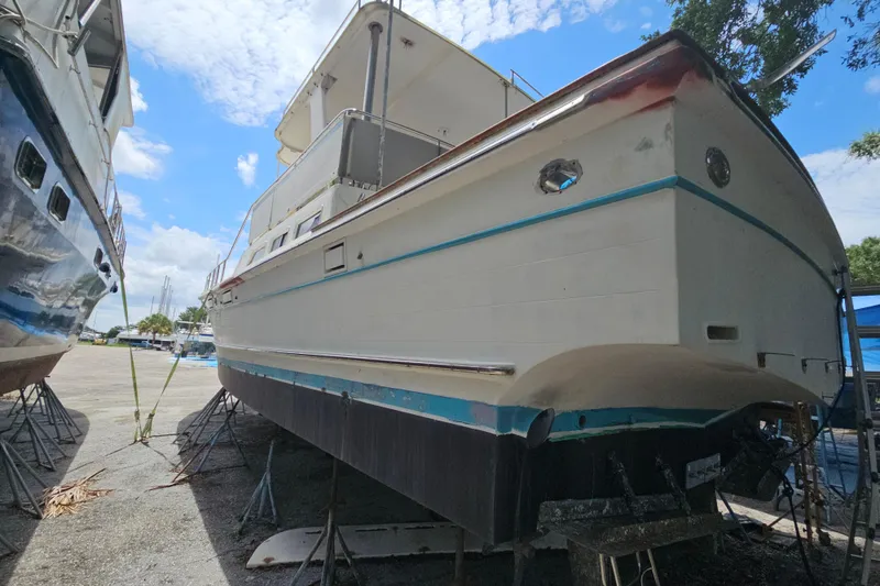 Slide: The Image of 1991 Offshore Yachts 48 Yachtfisher on dry dock under a bright blue sky. - 14