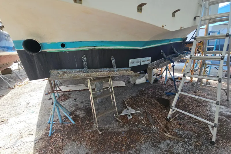 Slide: The Image of 1991 Offshore Yachts 48 Yachtfisher under maintenance, showing hull and propeller details. - 15