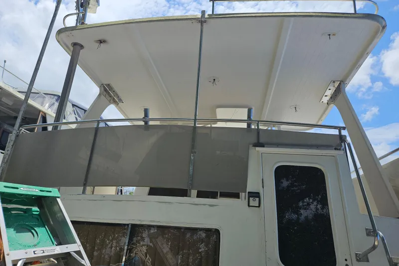 Slide: The Image of 1991 Offshore Yachts 48 Yachtfisher, exterior view with upper deck and ladder. - 18
