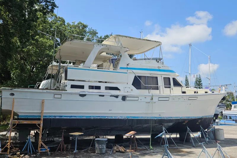 Slide: The Image of 1991 Offshore Yachts 48 Yachtfisher on dry dock, undergoing maintenance under a clear blue sky. - 2