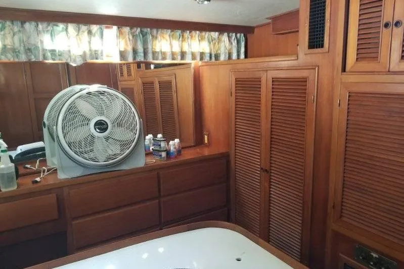 Slide: The Image of Interior of 1991 Offshore Yachts 48 Yachtfisher with wooden cabinetry and a fan. - 6