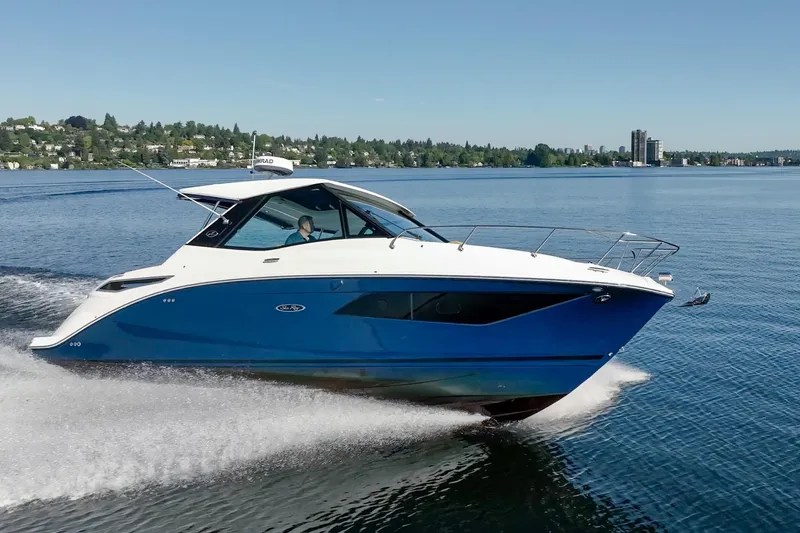 Slide: The Image of 2020 Sea Ray Sundancer 320 Coupe cruising on a serene lake under clear skies. - 10