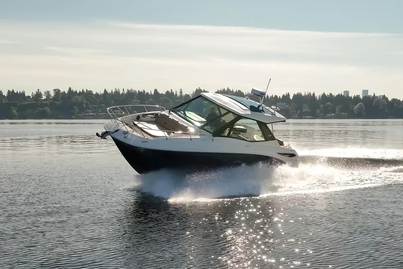 Slide: The Image of 2020 Sea Ray Sundancer 320 Coupe cruising on a serene lake under clear skies. - 11