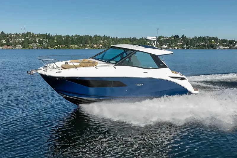 Slide: The Image of 2020 Sea Ray Sundancer 320 Coupe cruising on a serene lake under clear skies. - 12