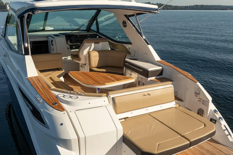 Slide: The Image of 2020 Sea Ray Sundancer 320 Coupe with luxurious seating and wooden accents on open water. - 15