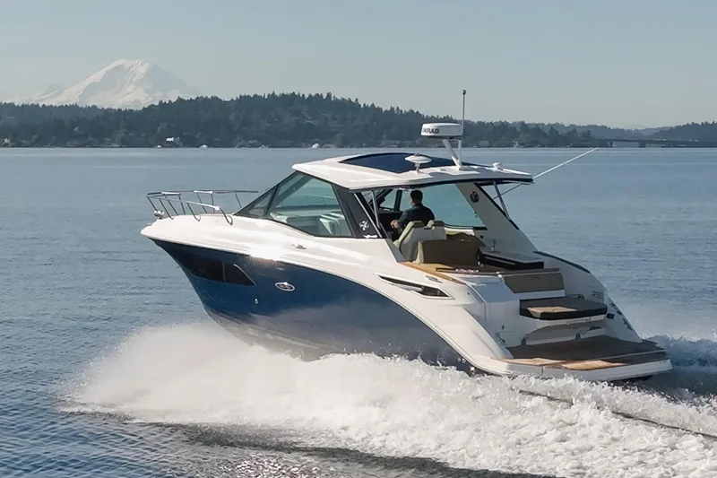 Slide: The Image of 2020 Sea Ray Sundancer 320 Coupe cruising on a serene lake with mountain backdrop. - 2