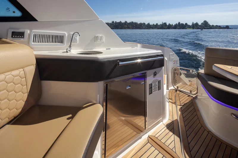 Slide: The Image of Luxurious 2020 Sea Ray Sundancer 320 Coupe interior with sleek seating and kitchenette on open water. - 23