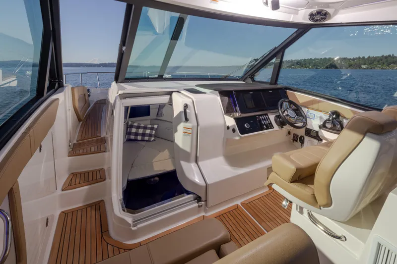 Slide: The Image of 2020 Sea Ray Sundancer 320 Coupe interior with helm, seating, and cabin view. - 25