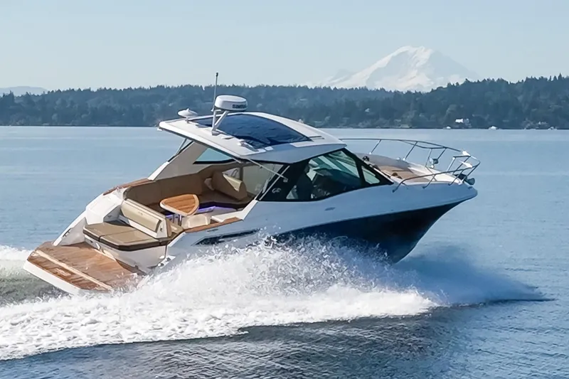 Slide: The Image of 2020 Sea Ray Sundancer 320 Coupe cruising on a serene lake with mountain backdrop. - 3