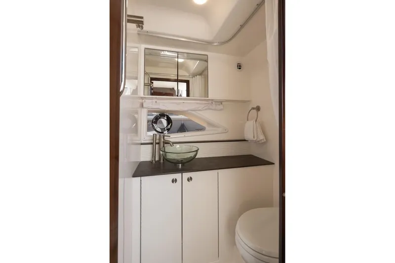 Slide: The Image of Modern bathroom in 2020 Sea Ray Sundancer 320 Coupe with glass sink and sleek cabinetry. - 39