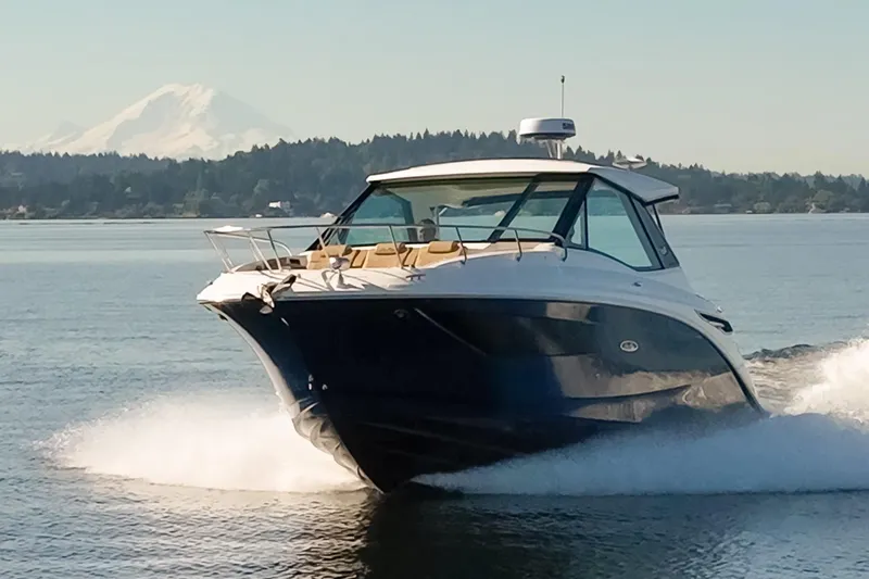 Slide: The Image of 2020 Sea Ray Sundancer 320 Coupe cruising on a serene lake with mountain backdrop. - 4
