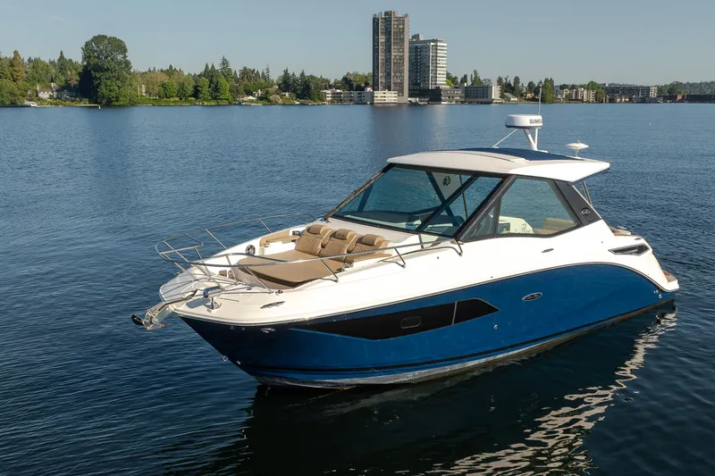 Slide: The Image of 2020 Sea Ray Sundancer 320 Coupe on a serene lake with cityscape background. - 7