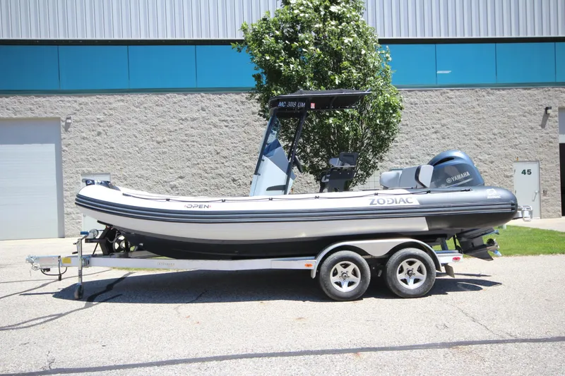The Image of 2020 Zodiac Open 6.5 boat on trailer, parked outdoors near industrial building. - 1