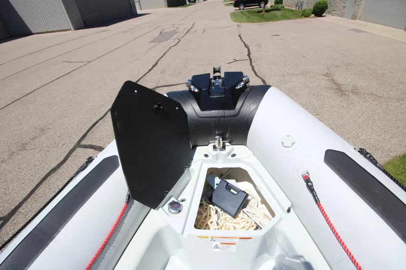 Slide: The Image of 2020 Zodiac Open 6.5 boat storage compartment with ropes and equipment. - 16