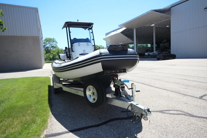 Slide: The Image of 2020 Zodiac Open 6.5 boat on trailer outside a large building. - 3