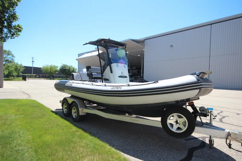 Slide: The Image of 2020 Zodiac Open 6.5 boat on trailer, parked outdoors near a building. - 4