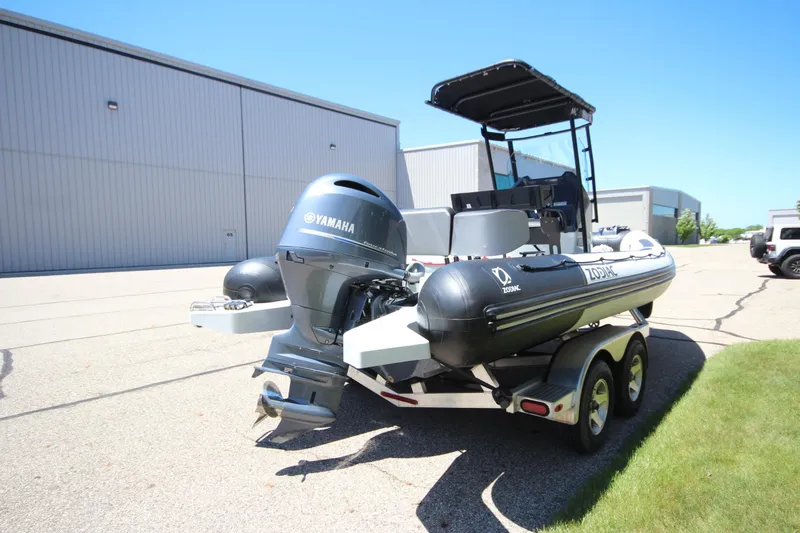 Slide: The Image of 2020 Zodiac Open 6.5 boat with Yamaha engine on trailer, parked outdoors. - 6